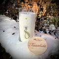 Trauerlicht Pusteblume. Allgäuer Heilkräuterkerze im Glas, Glas mit Aufdruck Pusteblume. Gravierter Holzdecke mit Aufschrift Trauerlicht. Szene im Schnee