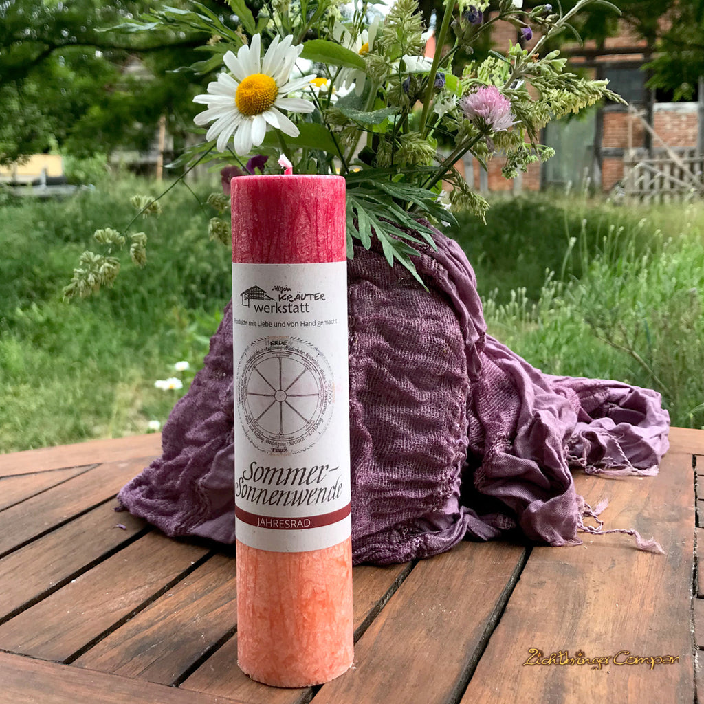 Sommersonnenwende Kerze mit Blumenstrauß. Ritualkerze der Allgäuer Heilkräutermanufaktur, aus der Serie Jahresrad. Rot und orange