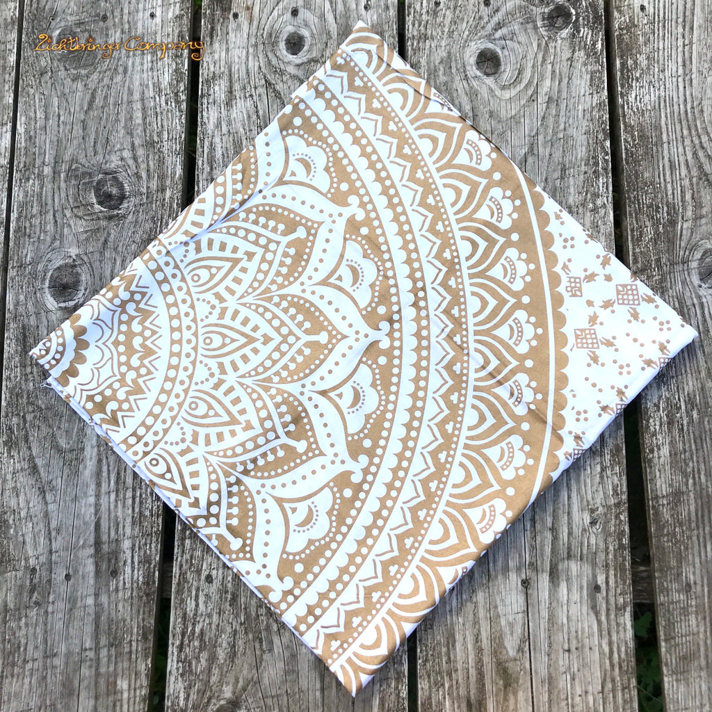 Detailaufnahme des goldenen Mandala-Musters auf weißem Tuch