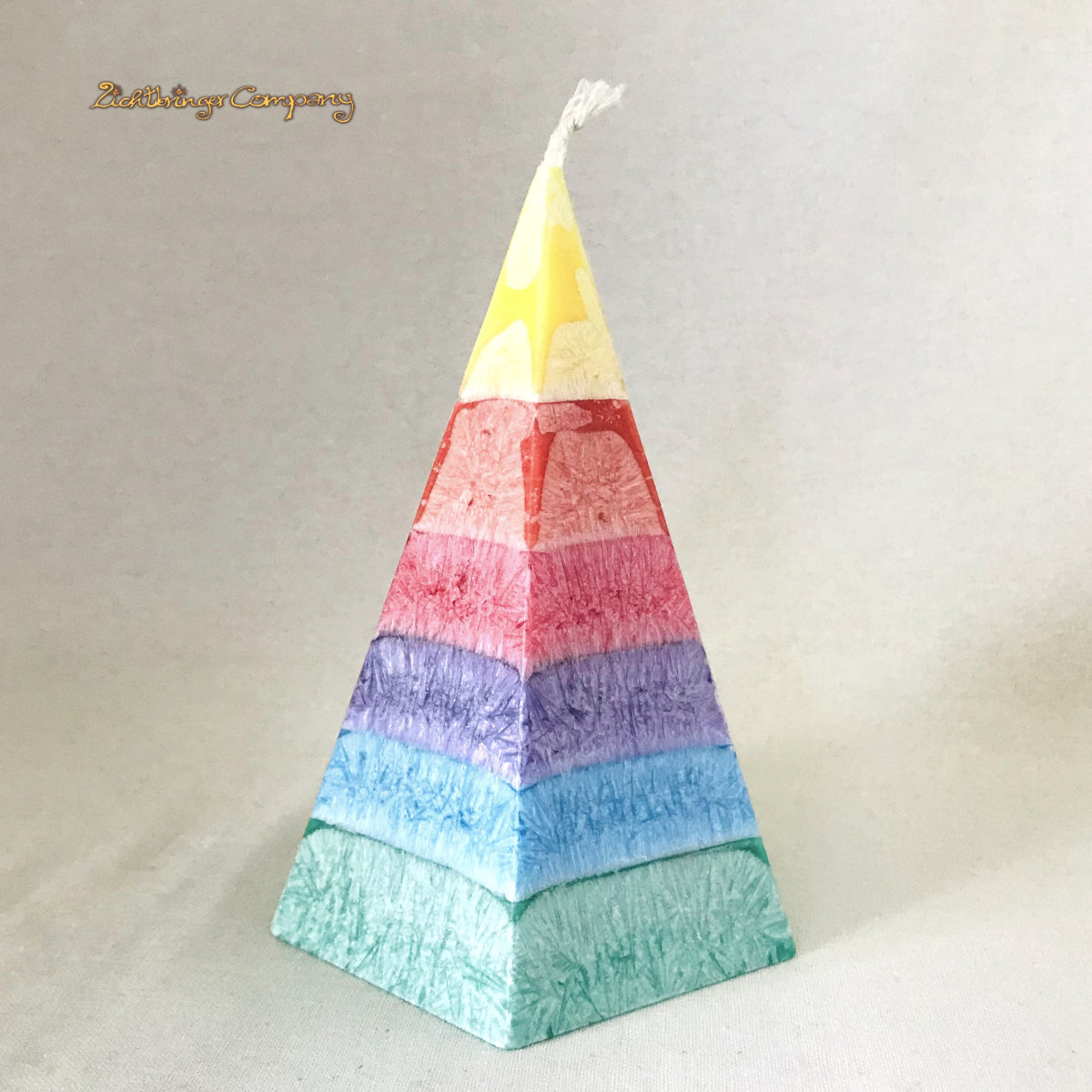 Regenbogenkerze in Pyramidenform, pro Farbschicht mit einem anderen Duft