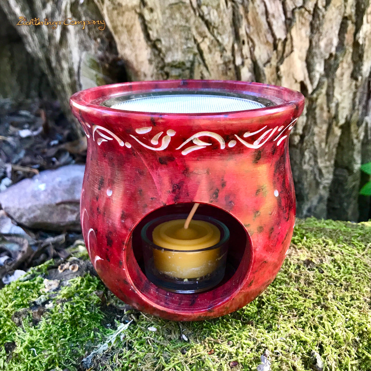 Rotes Räucherstövchen mit Sonnenblume aus Speckstein, Ansicht hinten mit Öffnung fürs Teelicht und ein Teelicht aus Bienenwachs
